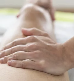 A massage therapists tends to a client's leg.