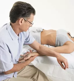 Til Luchau works on a supine client's wrist.