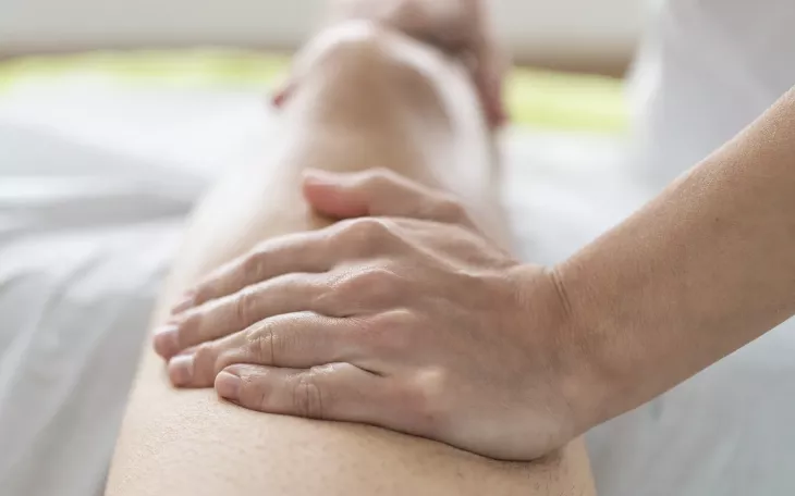A massage therapists tends to a client's leg.