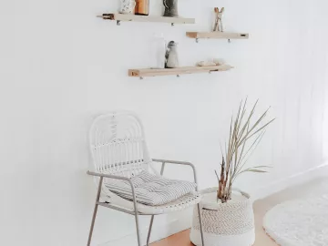 an empty waiting room with one chair and some wooden shelves. 
