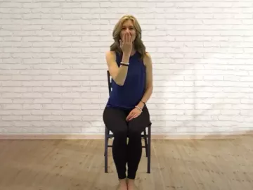 Author Angie Parris takes a deep inhale while seated in a chair.