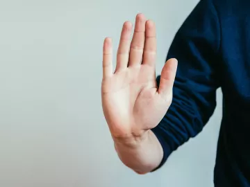 a hand raised up, making a stop gesture. 