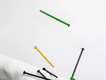 nails falling onto a statue of a human hand.