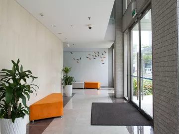 a modern office building hallway with orange couches and sunny light shining in.