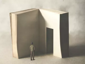 A conceptual image of a person looking at a book or story with a doorway in a page..