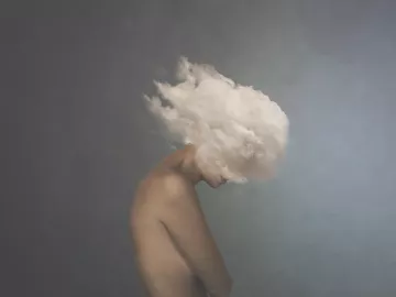 a nude person with their head literally in a cloud.