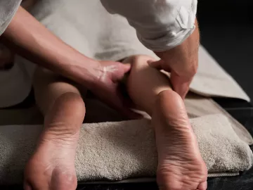 A massage therapist massaging a clients' leg.
