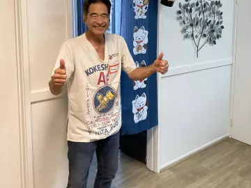 Jonathan Twidwell gives two thumbs up to the camera while standing in his studio.