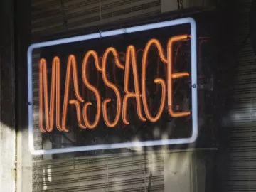 a neon fluorescent massage sign in a business window.