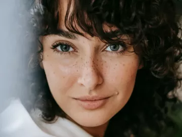 close up of a woman with brown hair looking at the camera.