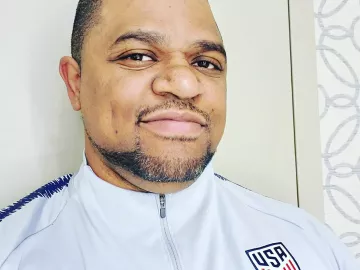 Desmond Diaz in a US Olympic team uniform smiles at the camera.