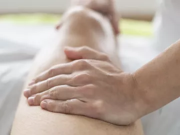 A massage therapists tends to a client's leg.