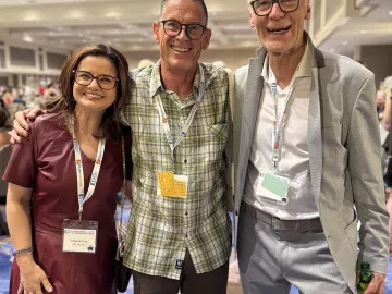 Three people pose for a photo in a conference room at the 7th Fascia Research Congress.
