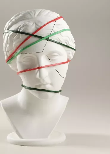 A cracked statue bust with bands around it holding it together.