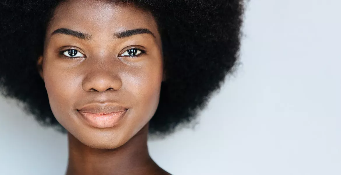 A Black woman smiles at the camera.