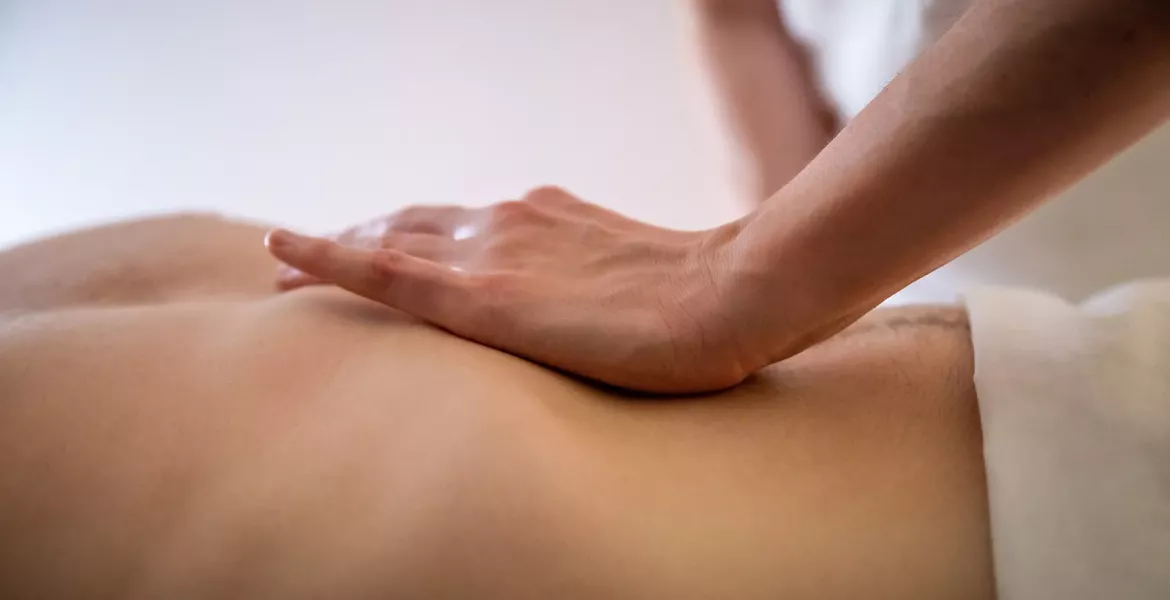 an MT's hand on the abdomen of a draped client.