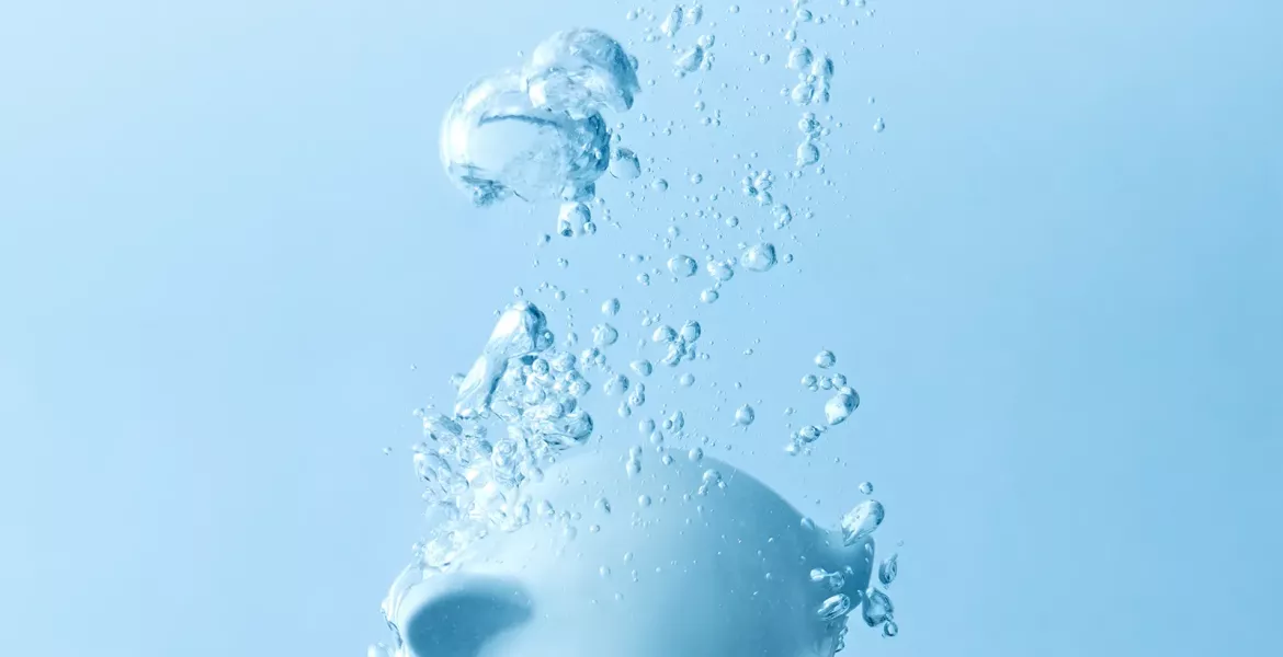 a light blue piggy bank sinks in water.