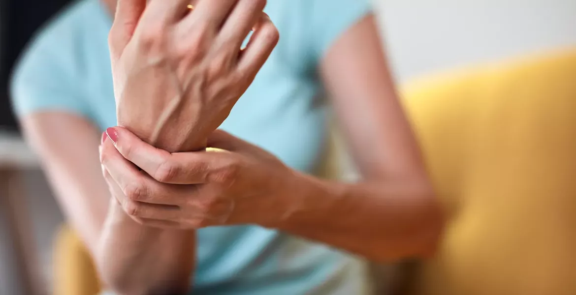 A female grasps her wrist.