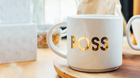 A coffee mug with the word “BOSS†emblazoned in gold lettering.