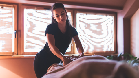 Young female therapist massages a client.
